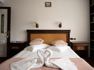 - un lit avec 2 cygnes en serviettes dans l'établissement Pensiunea TV Condor, à Sinaia
