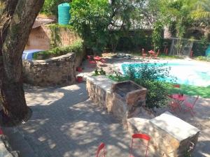 a backyard with a swimming pool and a stone wall at An Exclusive Guesthouse too in Nelspruit