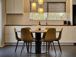 a kitchen with a table with chairs and wine glasses at Natuurvilla De Heerlickheyt in Hoogersmilde