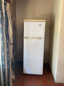 - un réfrigérateur blanc dans l'angle de la chambre dans l'établissement Lovely house on 4 hectares in John Galt Village - 2011, à Nyanga