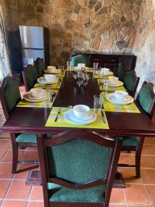 una mesa de madera con sillas y platos. en Lovely house on 4 hectares in John Galt Village - 2011 en Nyanga