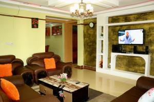 a living room with couches and a tv and a fireplace at Lokorye Homes in Makutano