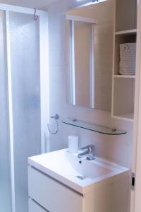 een witte badkamer met een wastafel en een spiegel bij LA MANSARDA Modern House in Verona