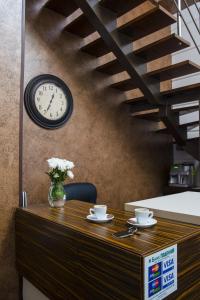 een tafel met twee kopjes en een klok aan een muur bij Apart Hotel Kvartira 1 in Odessa