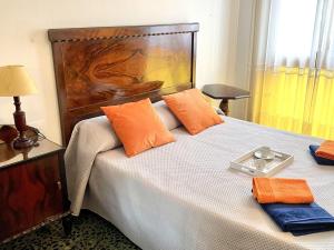 1 dormitorio con 1 cama grande con almohadas de color naranja en APARTBEACH CASA ALFORJA con VISTAS en Alforja
