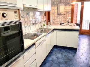 a kitchen with white cabinets and a sink at APARTBEACH CASA ALFORJA con VISTAS in Alforja