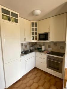 Una cocina con gabinetes blancos y un fregadero. en LUCKY Grazioso appartamento vista mare, en Son Bou