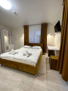 um quarto com uma cama, uma secretária e uma televisão em Naciku SPA Hotel em Bukovel