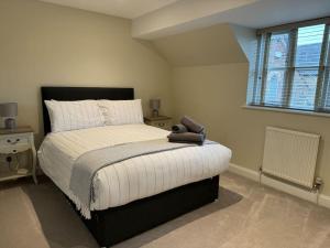 een slaapkamer met een bed met een teddybeer erop bij Central Village Cottage, The Corders in Moreton in Marsh