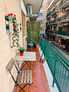 a balcony with a table and flowers on a building at Casa flowers in Ciampino