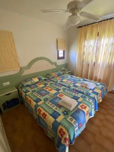 Un dormitorio con una cama con una colcha encima en LUCKY Grazioso appartamento vista mare, en Son Bou