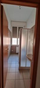 bagno con frigorifero e pavimento piastrellato. di Via Creti & Via Mazza Rooms a Bologna