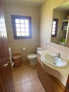 Un baño con lavabo, inodoro y espejo. en LUCKY Grazioso appartamento vista mare, en Son Bou