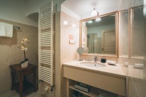 La salle de bains est pourvue d'un lavabo et d'un miroir. dans l'établissement Appia Hotel Residences, à Prague