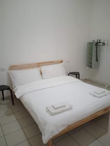 a bed with white sheets and white pillows at Via Creti & Via Mazza Rooms in Bologna