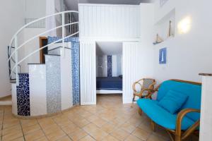uma sala de estar com uma cadeira azul e uma escada em Residence Le Terrazze em Sorrento