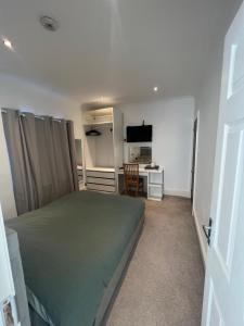 Dormitorio con cama, escritorio y TV en Eglentine en Londres