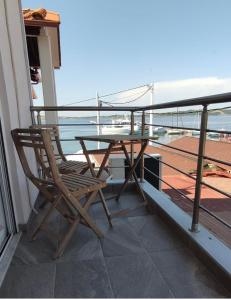 a wooden chair sitting on a balcony with a table at elenamou seaview rooms in Ammouliani