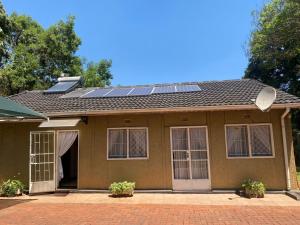une maison avec des panneaux solaires sur le toit dans l'établissement Cosy 3 bedroom cottage - 2034, à Kingsmead