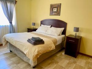 - une chambre avec un grand lit et 2 tables de chevet dans l'établissement Cosy 3 bedroom cottage - 2034, à Kingsmead