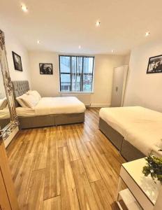 Habitación de hotel con 2 camas y ventana en Camden Apartments 2, en Liverpool