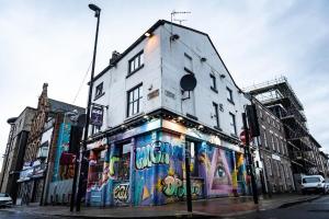 a building with graffiti on the side of it at Spacious Modern Retreat Sleeps 11 Liverpool City in Liverpool