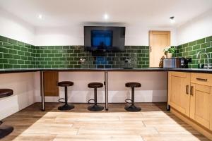 a kitchen with a counter with stools and a tv at Camden Apartments 2 in Liverpool +10 photos