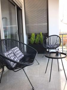 two chairs and a table on a balcony at B & K Luxury & Elegant Volos Suite in Volos