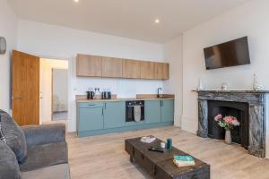 een woonkamer met een keuken en een open haard bij Seaside Serenity: Stylish Sea View Apartments in Herne Bay in Kent