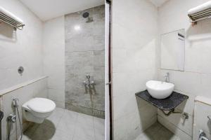 uma casa de banho com um chuveiro, um WC e um lavatório. em FabHotel Galaxy I em Ahmedabad