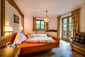 a bedroom with a bed and a desk and windows at Landhaus Bachtelmühle in Bolsterlang