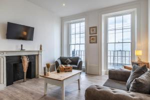 a living room with a couch and a fireplace at Seaside Serenity: Stylish Sea View Apartments in Herne Bay in Kent