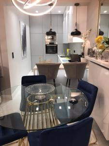 a kitchen with a glass table and blue chairs at B & K Luxury & Elegant Volos Suite in Volos