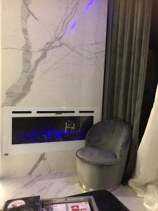 a living room with a chair and a fireplace at B & K Luxury & Elegant Volos Suite in Volos