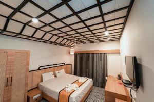 a bedroom with a bed and a flat screen tv at Vivera Highlands in Kodaikānāl