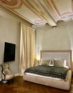 una camera con letto, TV e sedia di Domus Tua a Modena