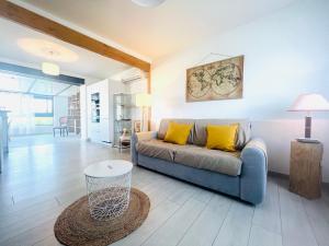 a living room with a couch and a table at Le Cottage - Jolie Maison à Buxerolles in Poitiers