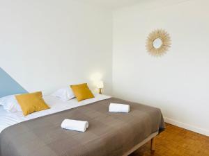a bedroom with a large bed with two towels on it at Le Cottage - Jolie Maison à Buxerolles in Poitiers +22 photos
