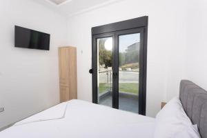 a bedroom with a bed and a sliding glass door at Lux et Mare in Pefkochori