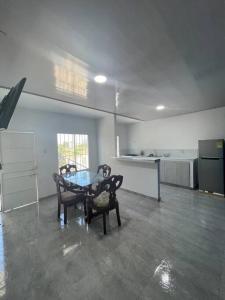 uma cozinha com mesa e cadeiras num quarto em Hostal el ebenezeer em Santa Marta