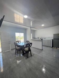 サンタ・マルタにあるHostal el ebenezeerのテーブルと椅子、キッチンが備わる客室です。