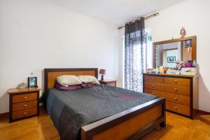 1 dormitorio con cama, tocador y espejo en Casa São Pedro, en Vila Franca do Campo