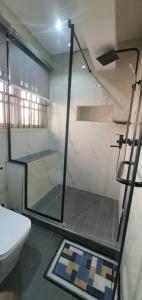 a bathroom with a glass shower and a toilet at ABODE APARTMENTS in Lagos