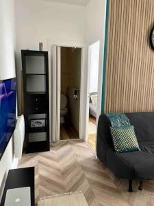 ein Wohnzimmer mit einem Sofa und einem TV in der Unterkunft Appartement accueillant aux portes de Paris in Bobigny