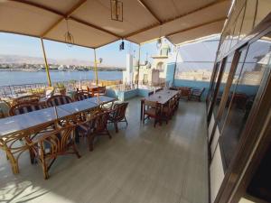 a balcony with tables and chairs on a cruise ship at Merryland Hotel Luxor in Luxor
