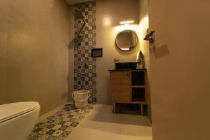 a bathroom with a toilet and a sink and a mirror at Vivera Highlands in Kodaikānāl