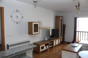 uma sala de estar com um relógio na parede em O Picho: apartamento céntrico. em Puentedeume