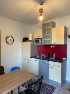 a kitchen with a table and a clock on the wall at Wolfis Appartement in Neusiedl an der Zaya