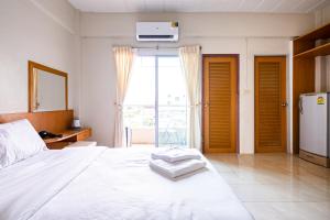 1 dormitorio con 1 cama blanca y nevera en GO INN Suvarnabhumi Airport โกอินน์ หน้าสนามบินสุวรรณภูมิ, en Lat Krabang