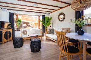 sala de estar con mesa y sillas en Cabana incl boat, jacuzzi,subboarts on a quiet park with private parking, en Loosdrecht